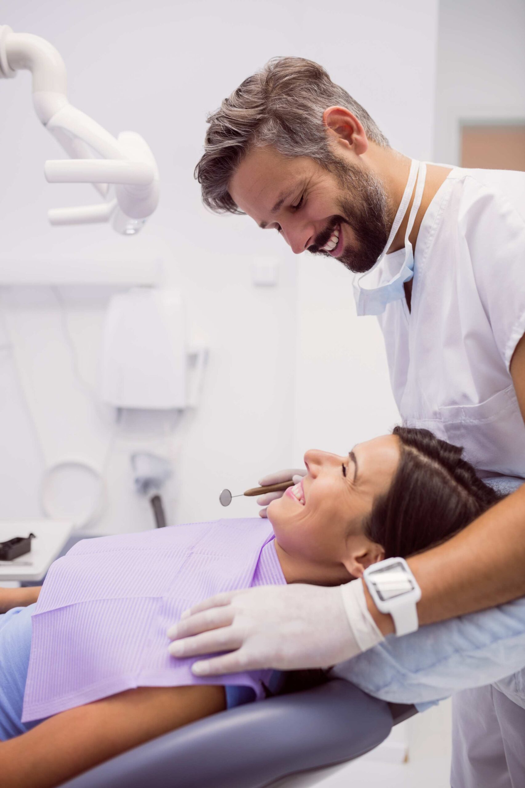 dentist-smiling-while-examining-patient